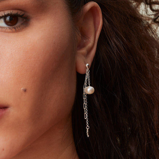 Pearl and sterling silver chain drop earrings worn on model