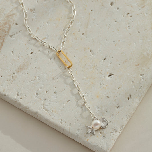 Silver lariat necklace with a star, pearl and initial charm at the end and connected with a gold vermeil clasp.