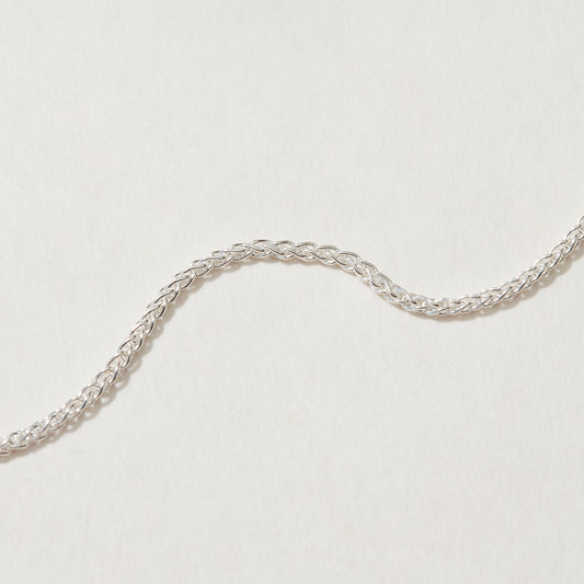 Close-up of Spiga Chain Necklace showcasing intricate silver design.