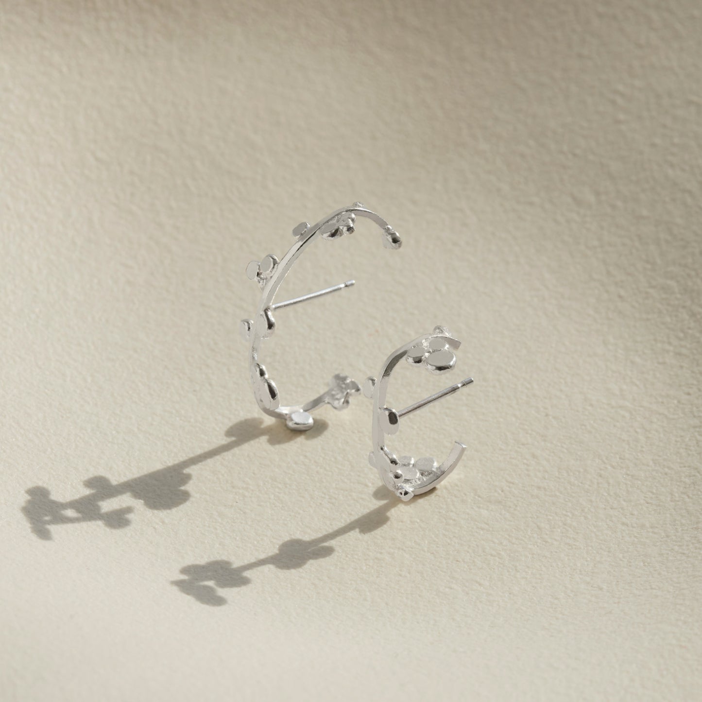 Two sizes of silver cuff earrings that wrap round the ear with dotted details.