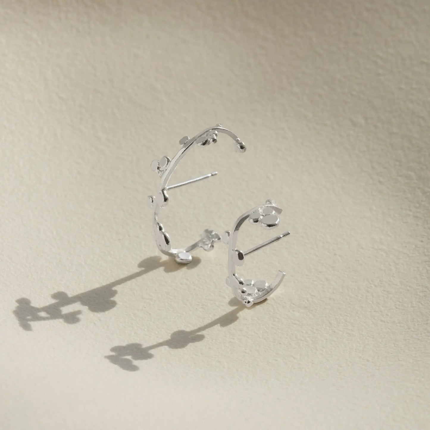 Two sizes of silver cuff earrings that wrap round the ear with dotted details.