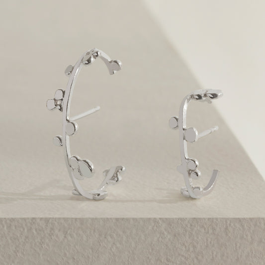 Silver cuff earrings with dotted details.