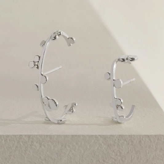 Silver cuff earrings with dotted details.