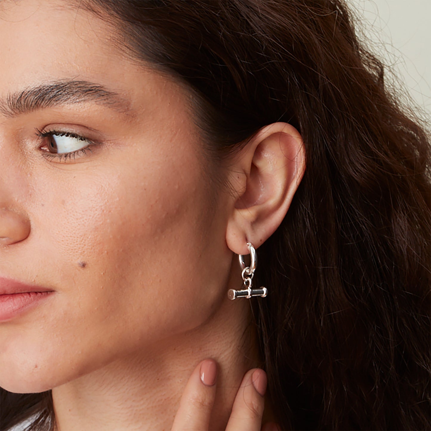 Close-up of model wearing sterling silver T Bar Hoop Earrings, showing the movement and chunky feel of the T bar drop.