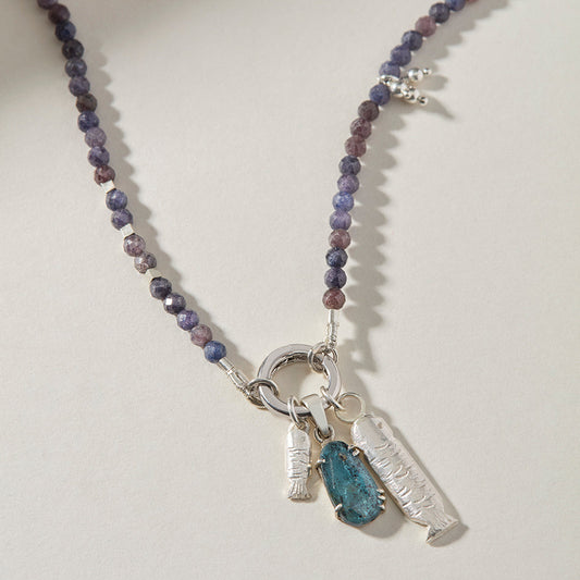 Close-up of handmade sterling silver sardine charms and hand-set kyanite gemstone