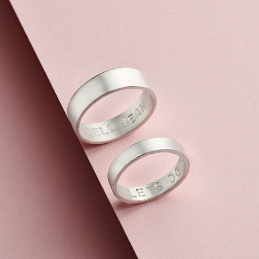 Personalised silver rings with hidden hand-stamped text, satin finish