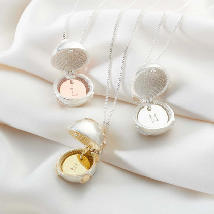 Open personalised globe lockets with hand-stamped initial discs in silver and gold finishes
