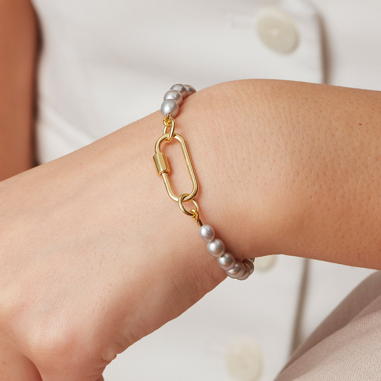 Lustrous grey pearl beaded bracelet with a large gold vermeil carabiner charm.