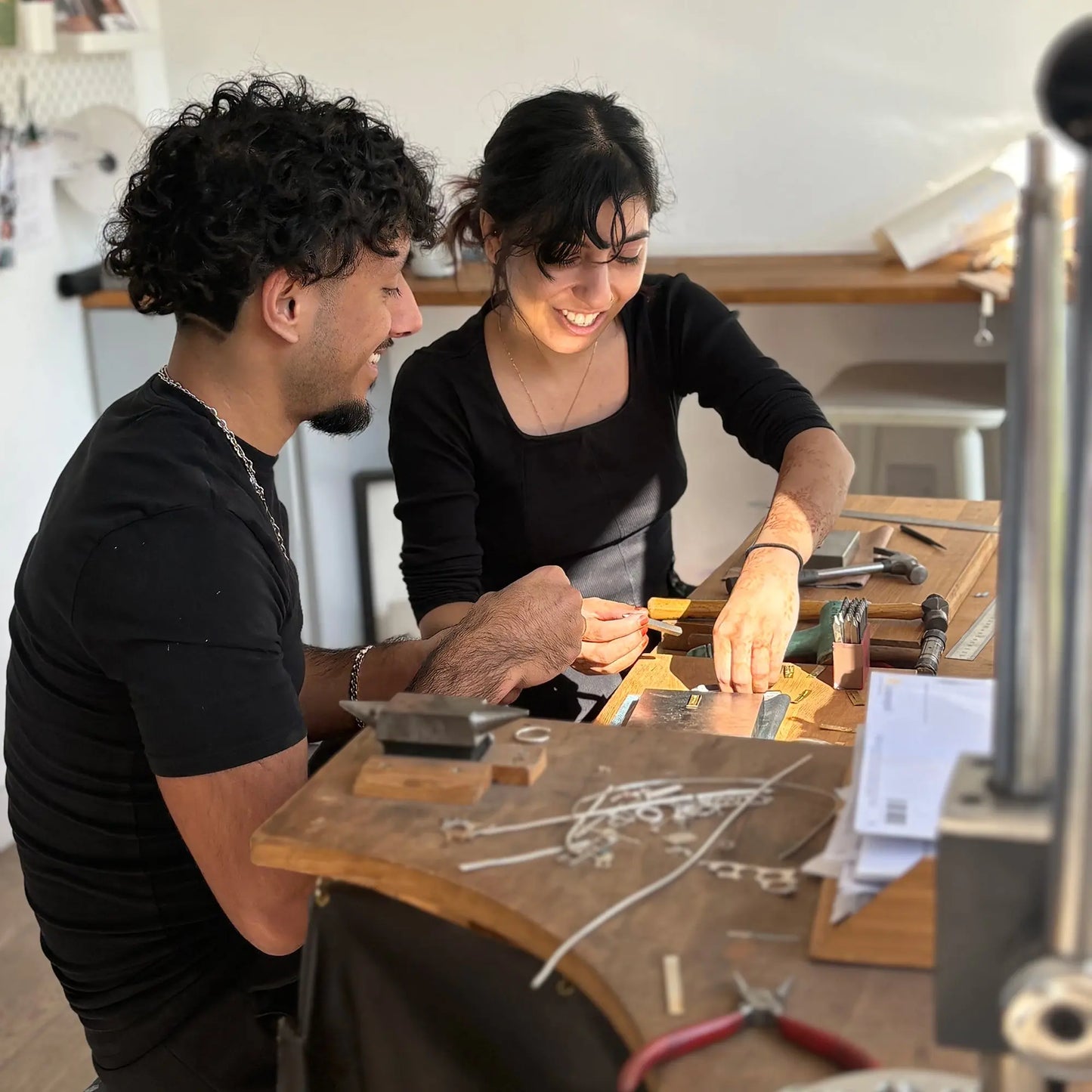 Two people making their own wedding rings together in the workshop