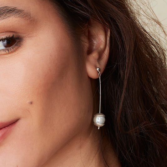 Model wearing pearl drop earrings