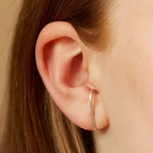 Model wearing the sterling silver slim cuff earrings that wrap round the ear.