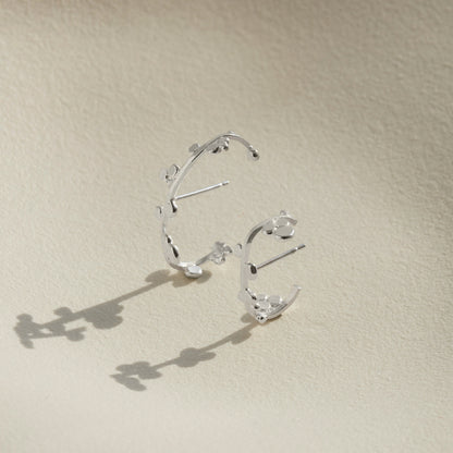 Two sizes of silver cuff earrings that wrap round the ear with dotted details. 