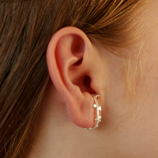 Silver cuff earrings that wrap round the ear with dotted details. 