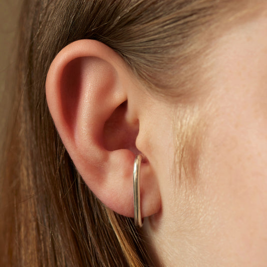 Model wearing the sterling silver cuff earrings that wrap round the ear.