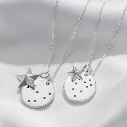 Close up of two different star signs displayed on Soremi's constellation disc necklace with the two options of large or small star charms.