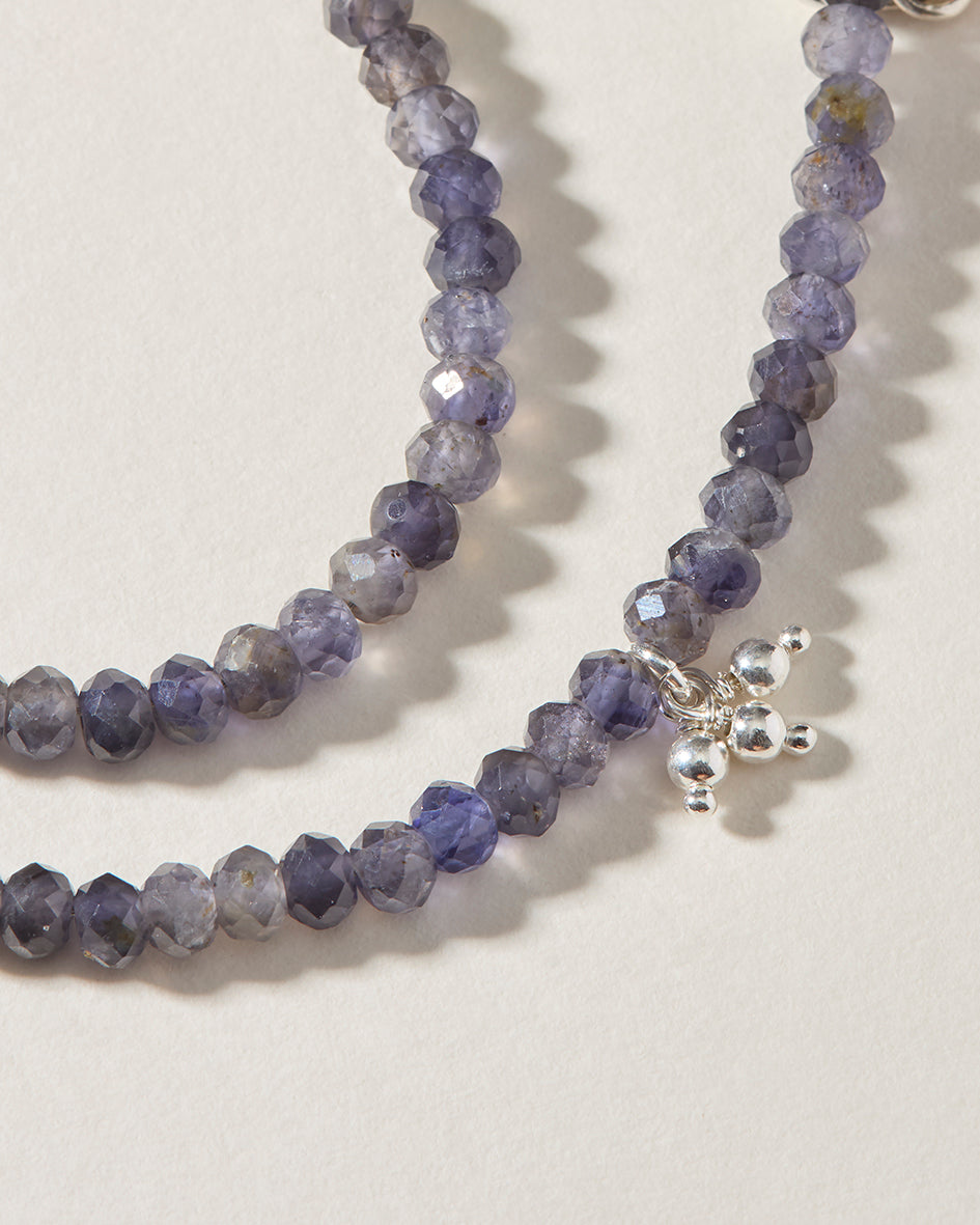 Close-up of faceted natural iolite beads with sterling silver granulated cluster detail