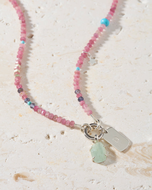 Personalised pink tourmaline dog tag necklace with hand-set aquamarine gemstone and sterling silver initial charm