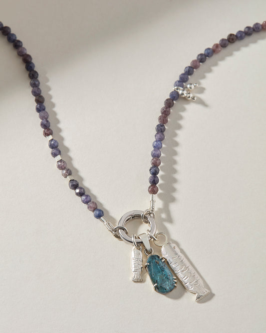 Close-up of handmade sterling silver sardine charms and hand-set kyanite gemstone