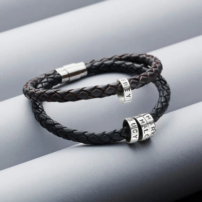 Black and dark brown men's braided leather bracelets with personalised sterling silver hoops and polished stainless steel clasps on a grey background.