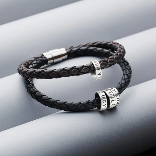 Black and dark brown men's braided leather bracelets with personalised sterling silver hoops and polished stainless steel clasps on a grey background.